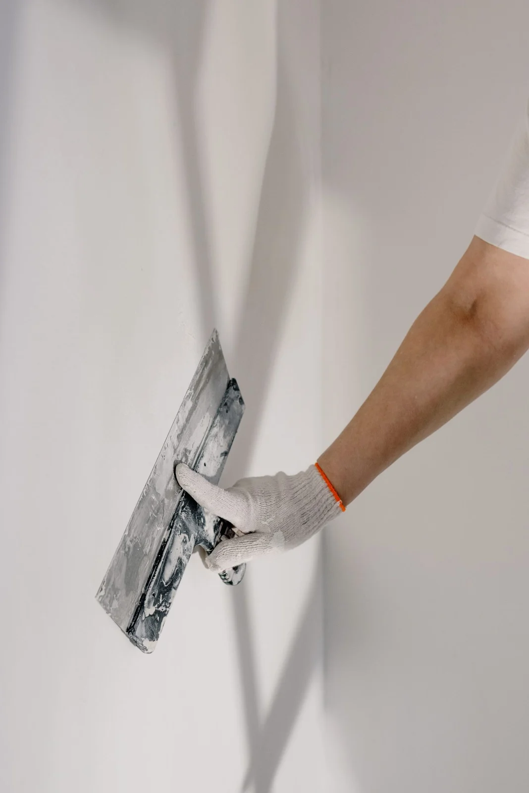 Tradesperson carefully finishing an interior wall