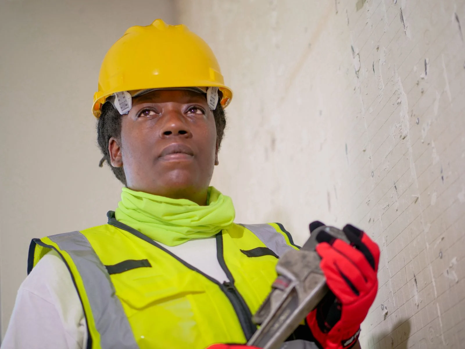 Construction worker wearing a hard hat and holding a tool